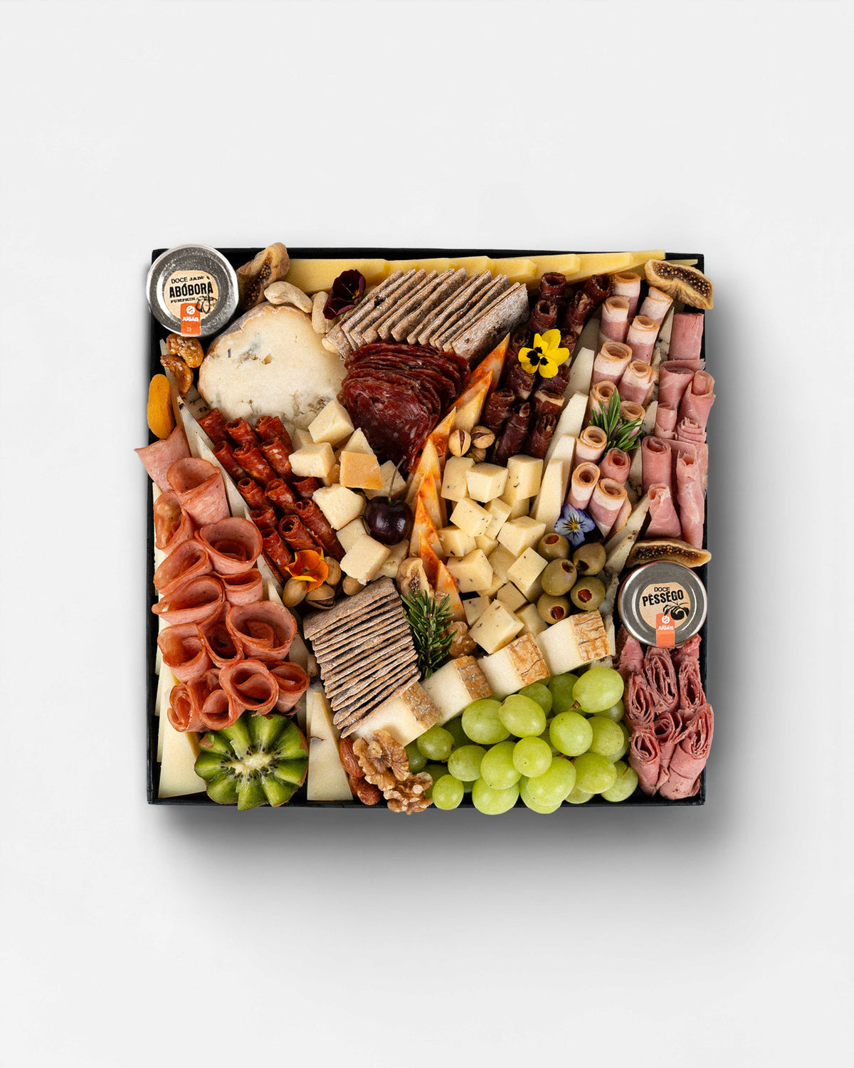 A 6 Month Aged cheese and charcuterie board arranged with assorted aged and semi-hard cheeses, rolled halal cold cuts, artisanal crackers, grapes, kiwi, figs, olives, nuts, and jams, showcasing varied textures and flavours in a generous platter. Cheese platter Dubai, charcuterie board Dubai, cheese board, cheese platter, gourmet food Dubai, charcuterie board, cheese platter delivery Dubai.
